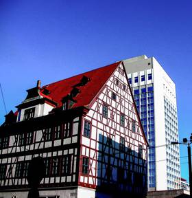 a 15th century merchants house in front of the 20th century hotel